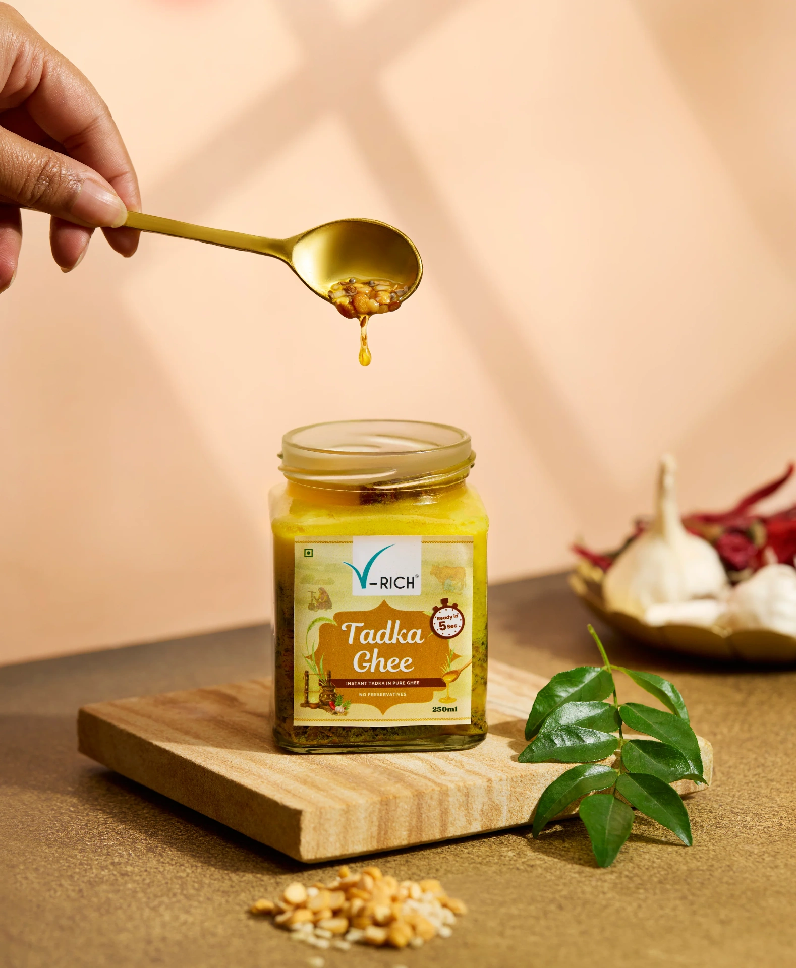 Golden spiced ghee being poured into hot dal
